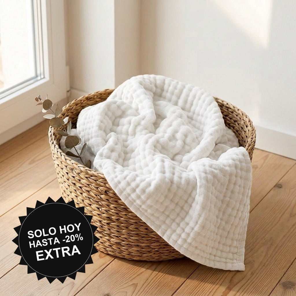 Manta de muselina NubeSuave color Blanco — en una cesta junto a la ventana
