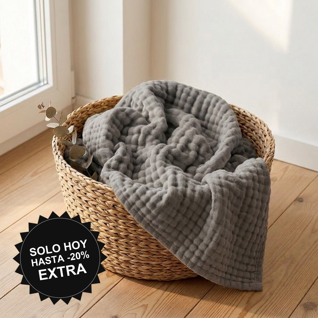Manta de muselina NubeSuave color Gris — en una cesta junto a la ventana